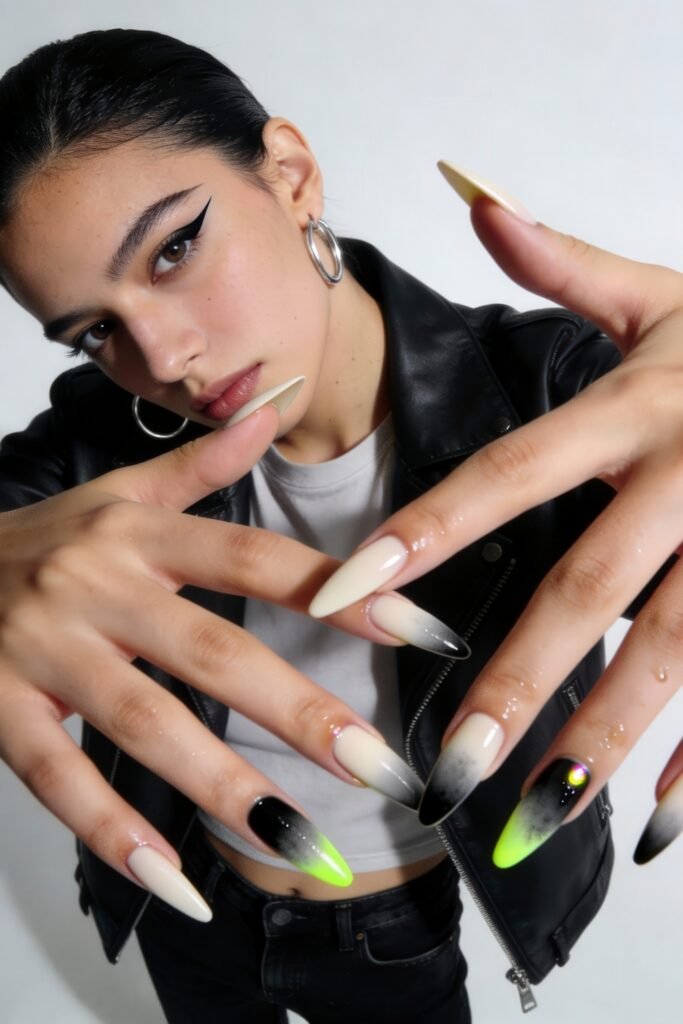 Model in a leather jacket displaying long almond-shaped nails with a gradient design in cream, black, and neon green, blending elegance with bold street style nails energy.