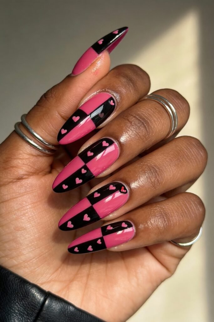 Black And Pink Nails That Look Instantly Chic 2 A creative checkered nail design where each nail is split into black and pink halves, decorated with tiny pink hearts across the pattern, for a fun and eye-catching black and pink nails style.