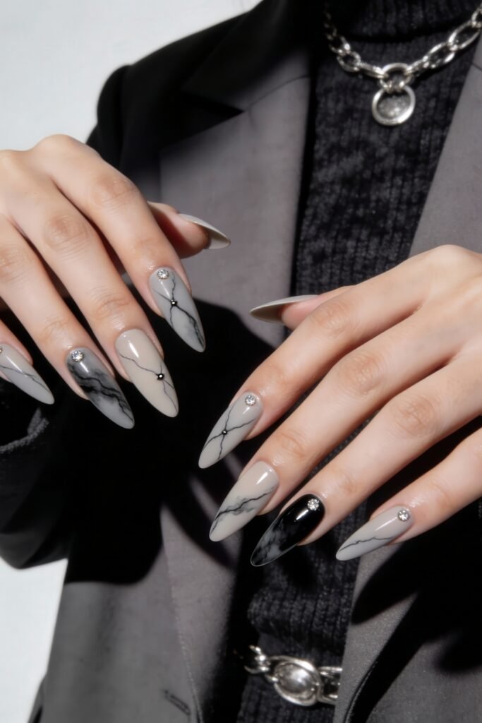 Long almond nails in soft greys and blacks with marble textures, rhinestones, and fine black veining, blending modern luxury with bold Nail Art Ideas.