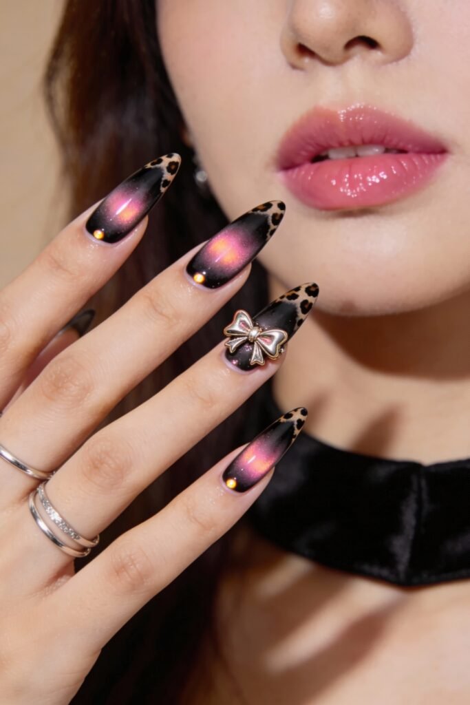 Black And Pink Nails That Look Instantly Chic 18 Shimmering black and pink nails with a magnetic cat-eye effect, leopard print tips, and a golden bow charm, finished with small gemstones for added sparkle.