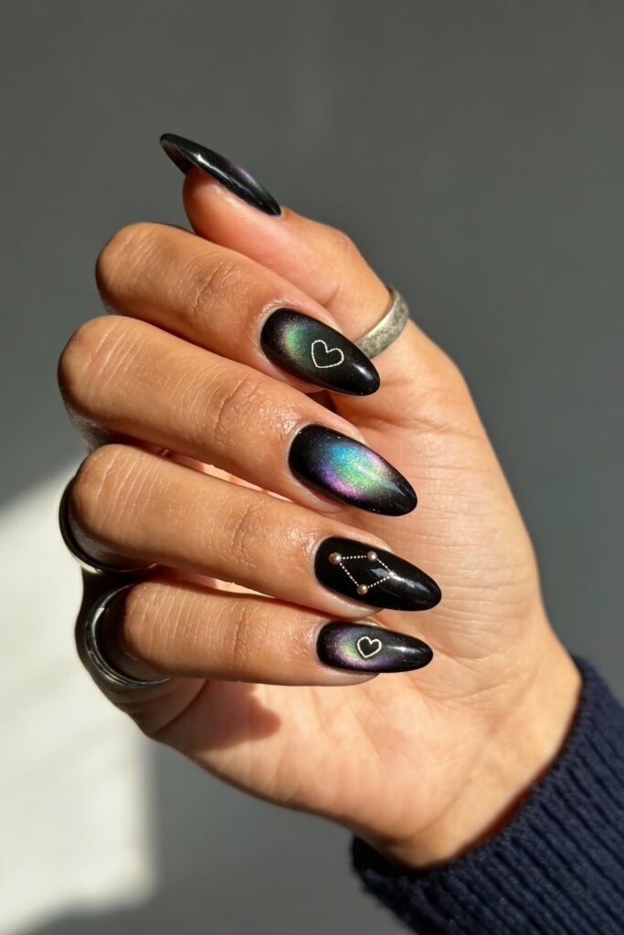 Black Valentines Day Nails That Feel Chic And Romantic 20 Almond-shaped black valentines day nails with an iridescent aurora effect, featuring metallic heart outlines and a gold constellation design for a dreamy celestial vibe.