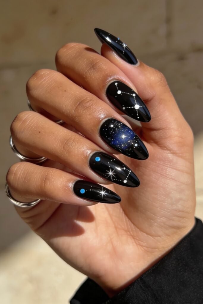 Swaggy Nails That Look Cool and Expensive 19 Shiny black stiletto nails adorned with hand-painted constellations, glowing stars, and tiny planets, bringing celestial Nail Art Ideas to life with a cosmic flair.