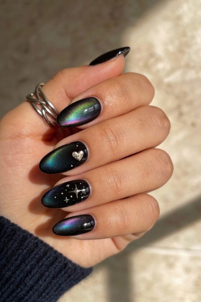 Black Valentines Day Nails That Feel Chic And Romantic 21 Black valentines day nails with a shimmering multichrome finish, decorated with a metallic heart charm and tiny stars, blending cosmic and romantic elements.