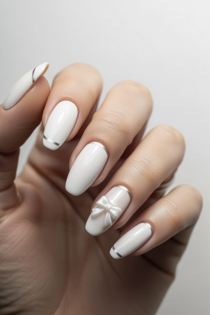 Milky White With Chrome Nails That Look Luxe 21 Glossy white nails with delicate chrome striping and a 3D white bow on the ring finger, blending elegance with a playful, feminine accent.
