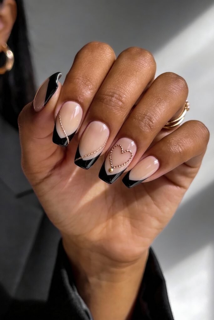 Black Valentines Day Nails That Feel Chic And Romantic 23 Glossy black french tip nails on a nude base, accented with gold bead chains and a gold-outlined heart on the ring finger, giving a refined black valentines day look.