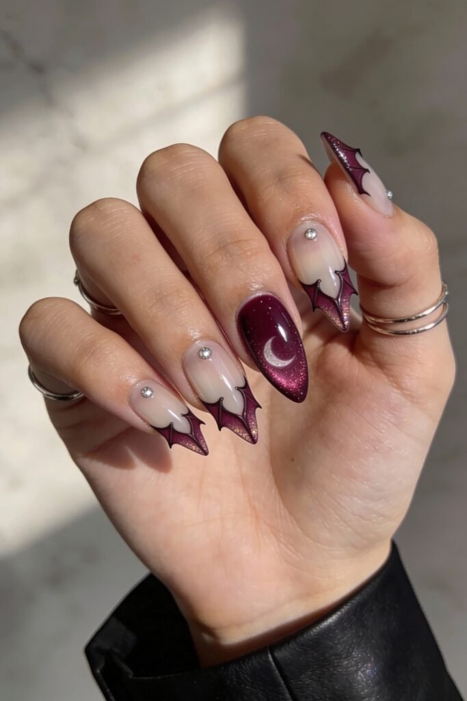 Gothic Valentines Nails That Feel Dark and Romantic 20 Stiletto gothic valentines nails with bat-wing shaped burgundy glitter tips, silver studs, and a full glitter accent nail featuring a crescent moon.