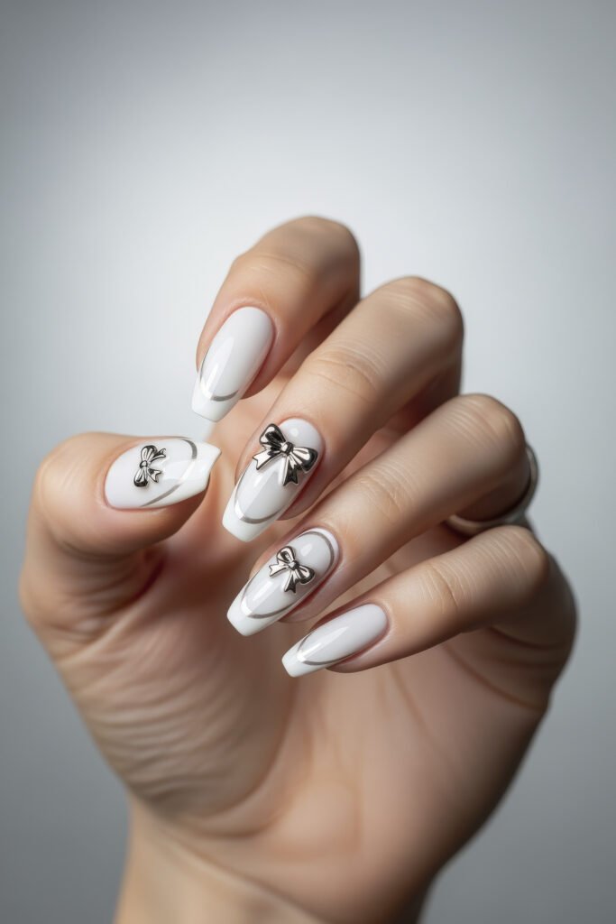 Milky White With Chrome Nails That Look Luxe 22 Milky white nails with subtle chrome outlines and metallic bow embellishments on several fingers, combining dainty charm with modern flair.