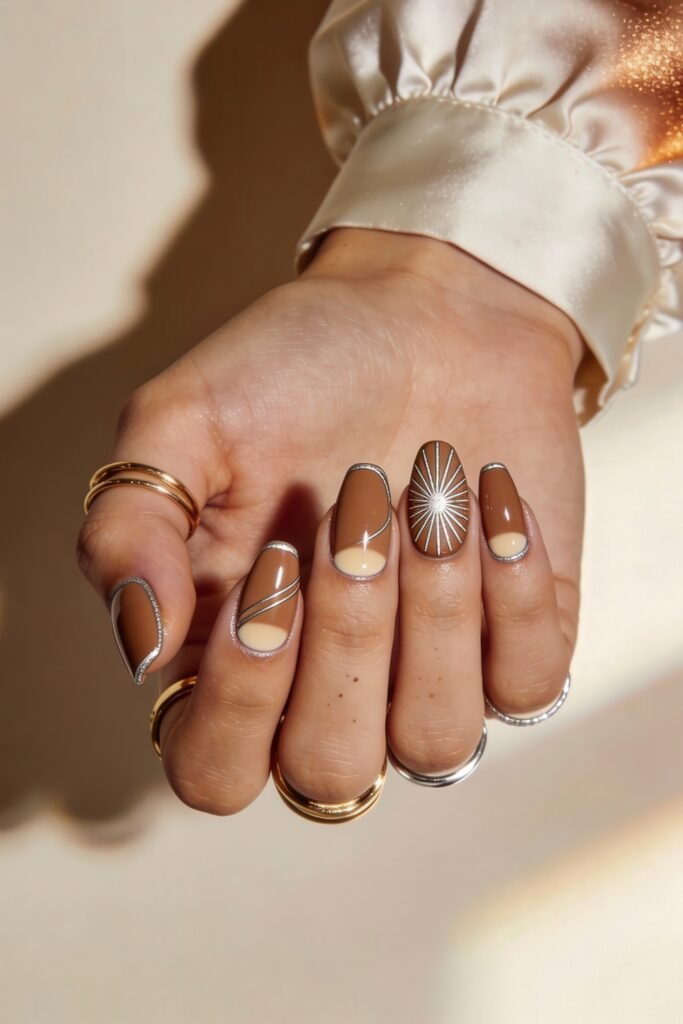 Swaggy Nails That Look Cool and Expensive 21 Almond nails in warm brown and nude tones with delicate silver outlines and one radiant starburst accent nail, offering refined, swaggy nails with a luxe finish.