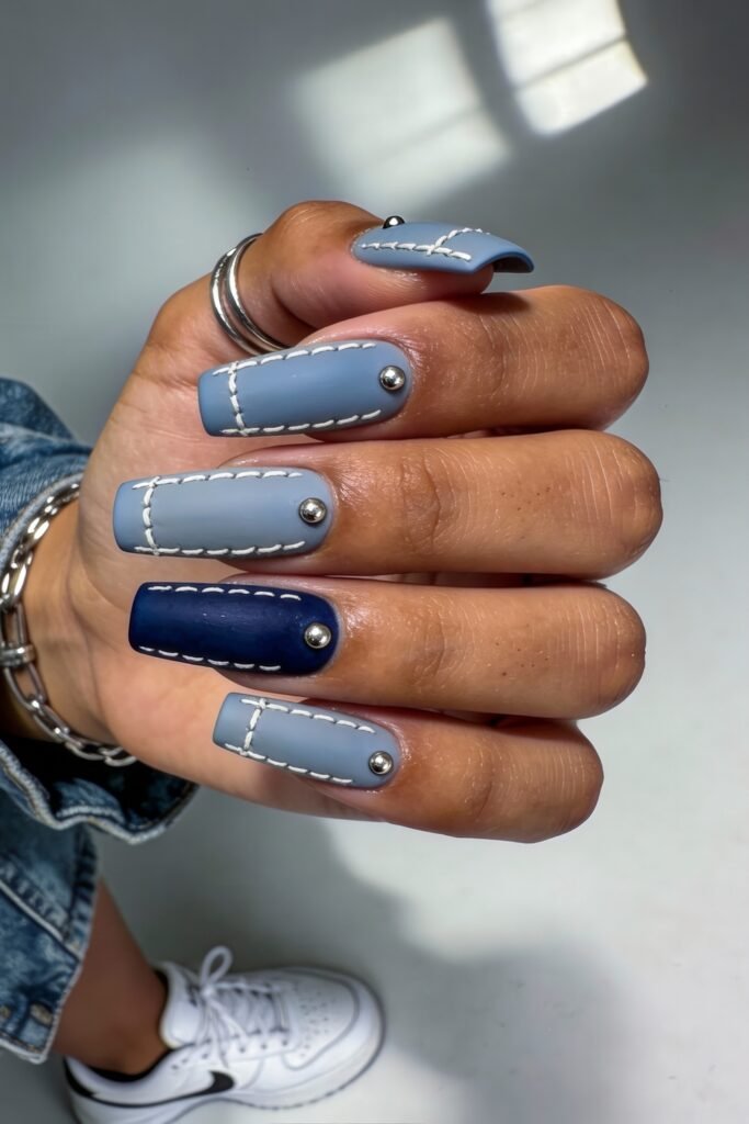 Swaggy Nails That Look Cool and Expensive 22 Matte square nails in shades of dusty blue and navy, detailed with white stitch lines and metallic studs, channeling denim vibes in a cool, swaggy nail design.