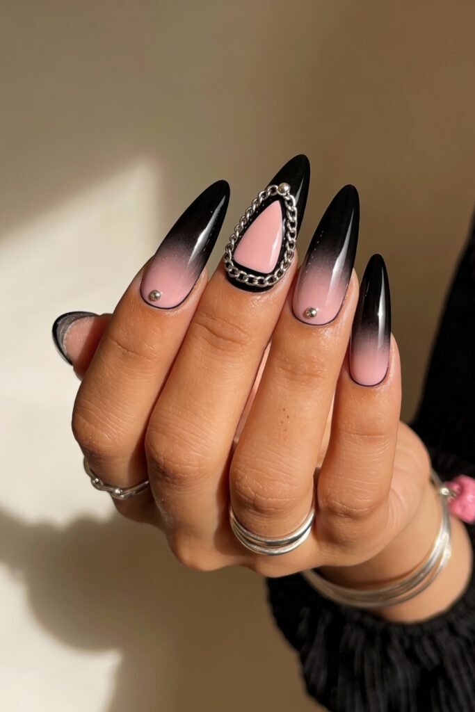 Black And Pink Nails That Look Instantly Chic 21 Long almond-shaped nails with a black to pink ombré effect, accented by silver studs and a bold statement nail featuring a silver chain framing a pink and black design.