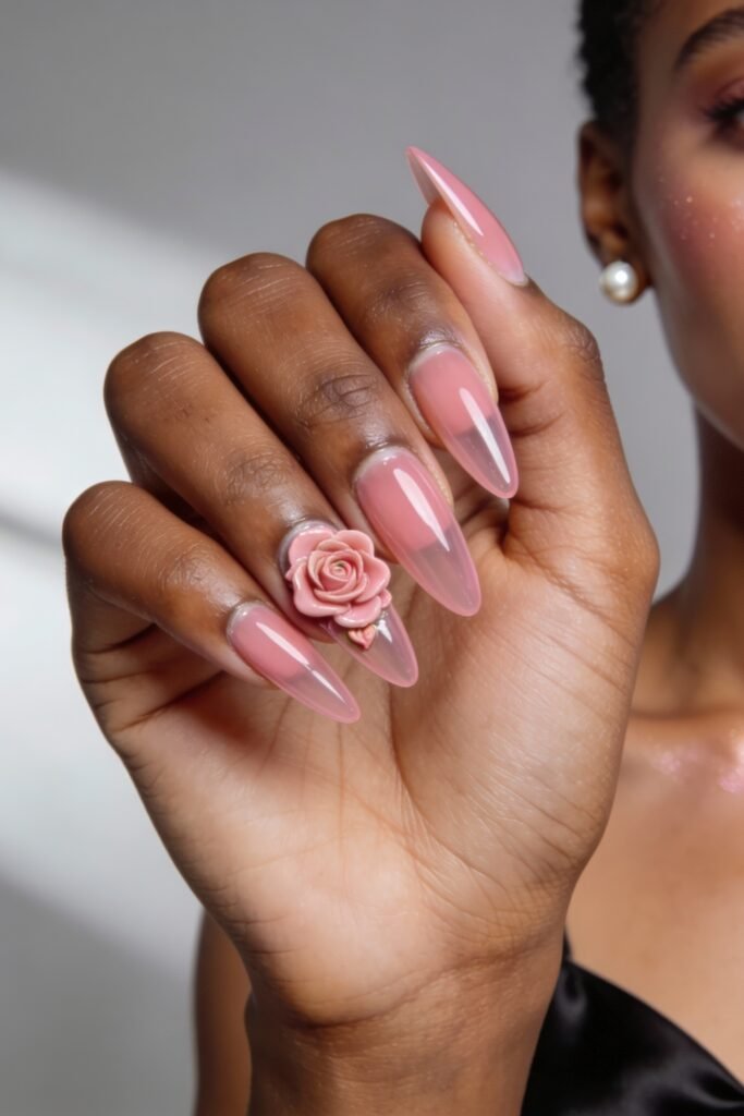 Pink Valentines Nails That Feel Chic, Glossy, and New 25 Long almond-shaped pink valentines nails with a glossy ombré finish, highlighted by a sculpted rose and tiny gold heart accent.