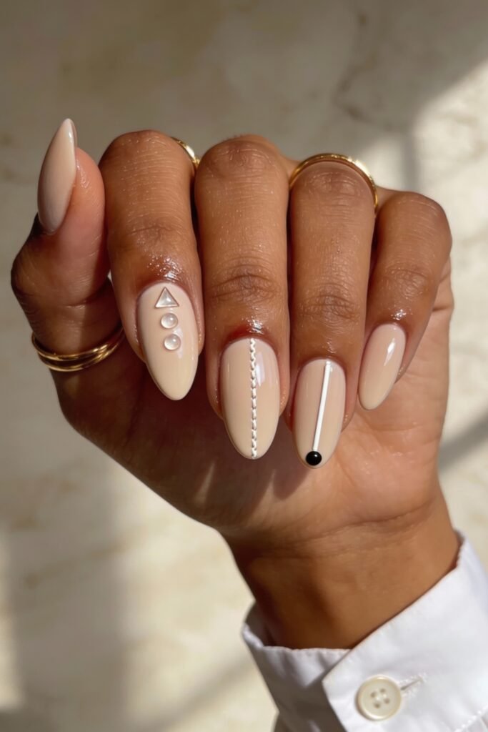 3d Nail Art Ideas That Look Luxe and Wearable 25 Neutral almond nails featuring simple geometric 3d nail art in white and black, with triangle, dot, line, and stitch motifs adding a minimalist, modern edge.