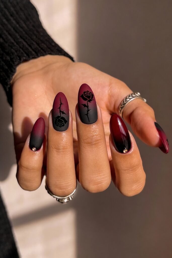 Gothic Valentines Nails That Feel Dark and Romantic 26 Matte burgundy and black ombré gothic valentines nails with black rose and thorn silhouettes, accented with tiny gold studs for a striking contrast.