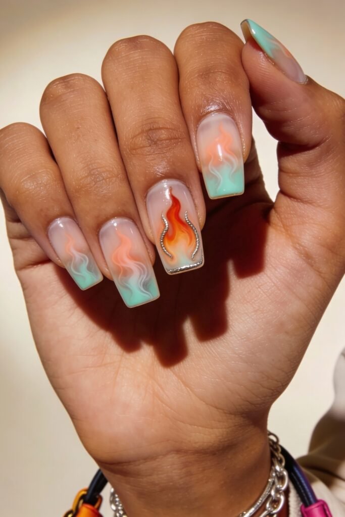 Swaggy Nails That Look Cool and Expensive 29 Square nails featuring pastel flame gradients in orange, pink, and mint green on a translucent base, with a crystal-trimmed flame accent for standout Nail Art Ideas.