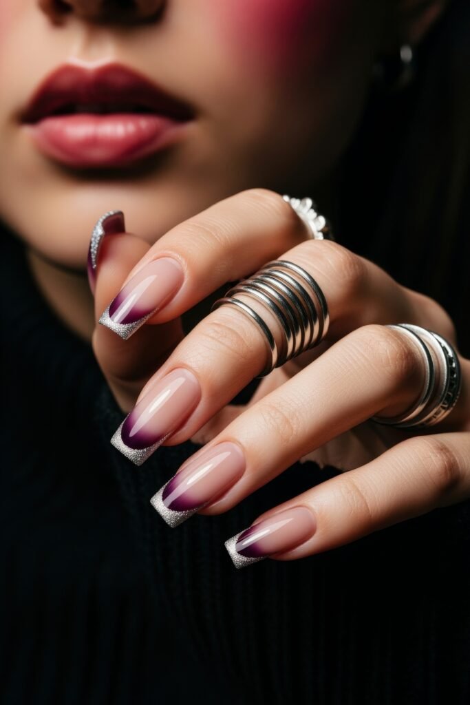 Hand showcasing squared nails with a nude base and deep purple ombré tips, outlined in silver glitter for a refined and frosty winter nails aesthetic.