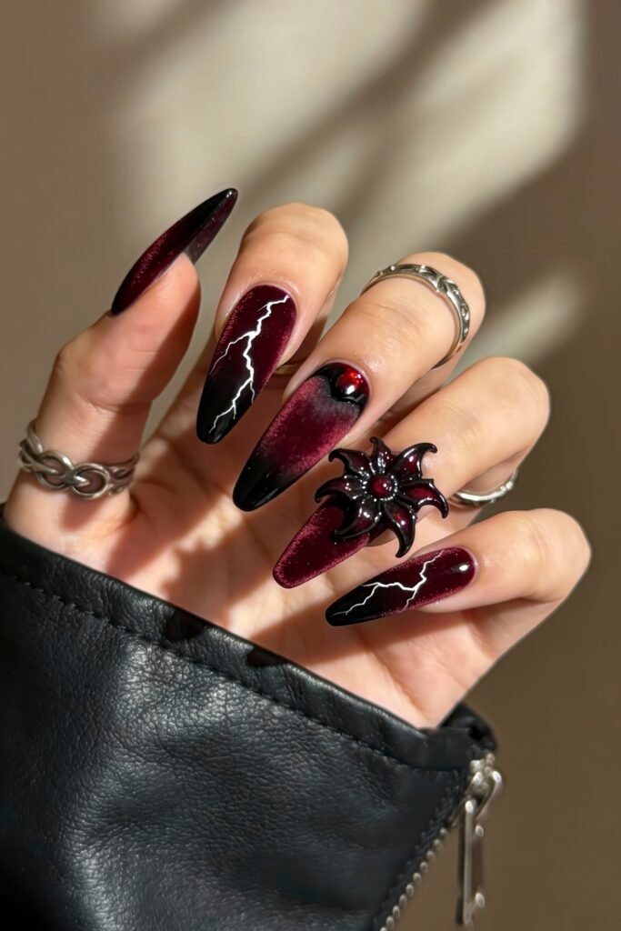 Long, stiletto-shaped nails painted in deep maroon and black with lightning bolt accents, a black-red gradient, and a 3D flower resembling the Demogorgon, inspired by Stranger Things.