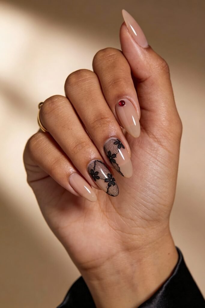 Black Valentines Day Nails That Feel Chic And Romantic 5 Soft nude nails with black mesh floral lace details and a single red gem accent, creating a romantic and refined black valentines day nail design.