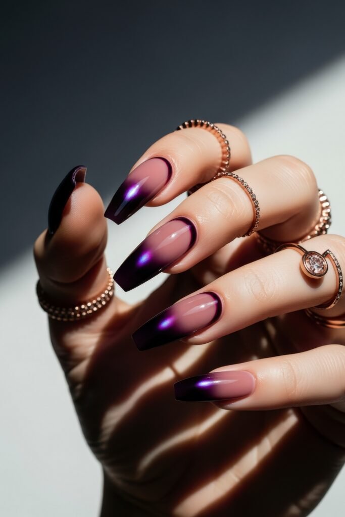 Long square nails with a mauve base and glossy purple-to-black gradient tips, catching the light with a luminous sheen for a bold Winter Nails look.