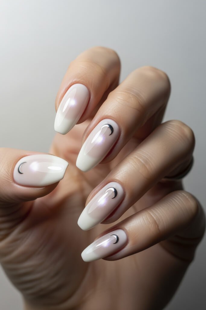 Milky White With Chrome Nails That Look Luxe 6 Almond-shaped nails with a soft white base and tiny chrome crescent moons near the cuticles for a subtle moon phase theme.