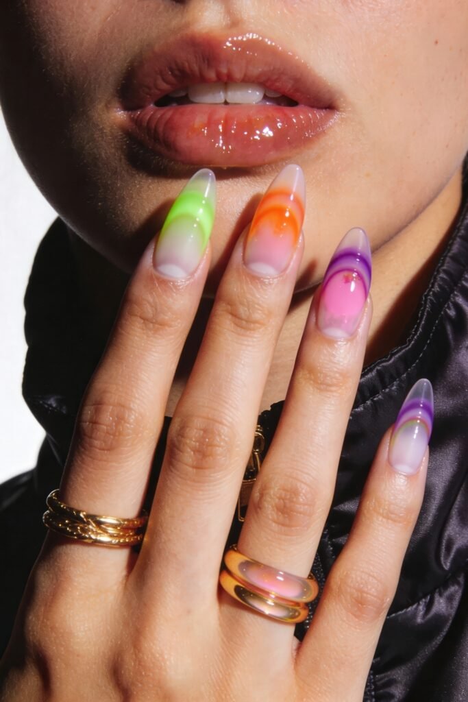 Swaggy Nails That Look Cool and Expensive 6 Close-up of multicolored jelly ombré nails in shades of green, orange, pink, and purple, glowing with glossy intensity—fresh Nail Art Ideas for a bold look.