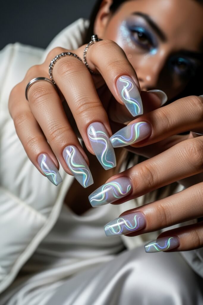 Close-up of hands with long square nails decorated with holographic pastel swirl designs on a sheer frosty base, blending futuristic flair with Winter Nails inspiration.
