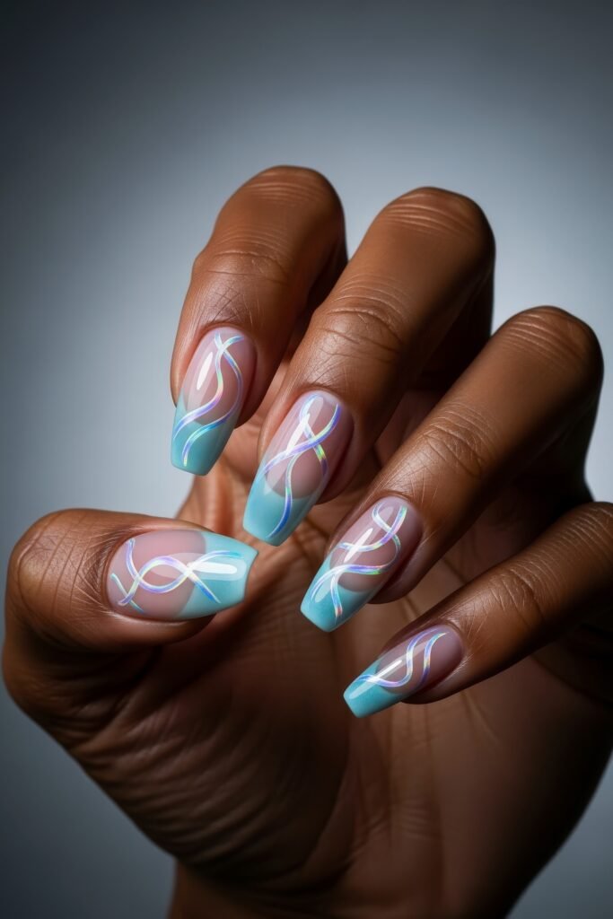 Manicured hand with soft square nails featuring icy blue tips and holographic ribbon-like swirls, combining shimmer and elegance for a modern Winter Nails style.