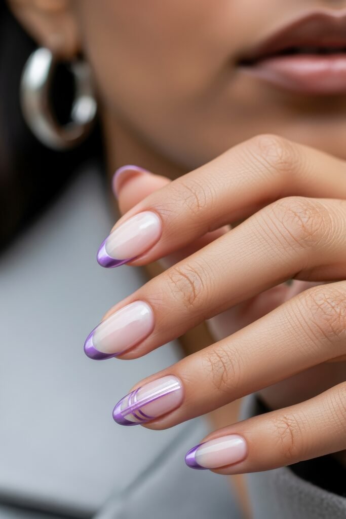 Close-up of almond nails with a pale pink base and soft purple French tips, enhanced by minimalist swirl line art, evoking a refined purple winter nails feel.