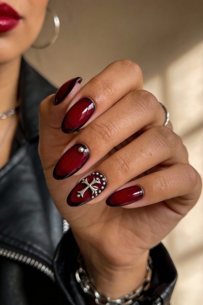Gothic Valentines Nails That Feel Dark and Romantic 9 Deep red glossy gothic valentines nails with black borders, adorned with a raised silver cross and stud accents on the ring finger.