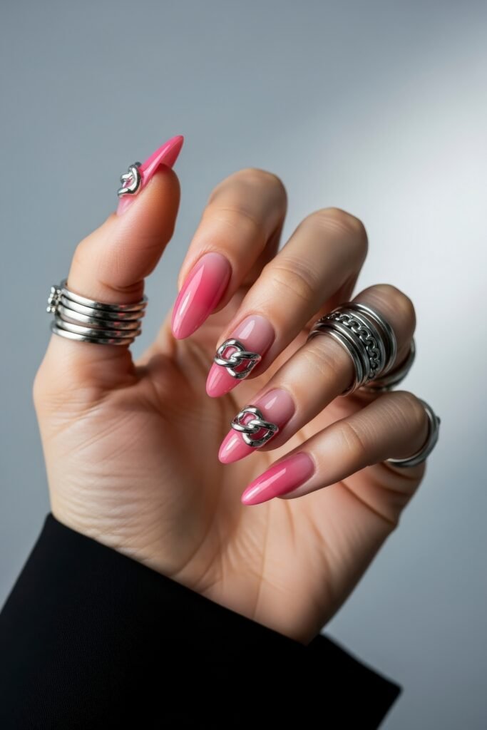 Swaggy Nails That Look Cool and Expensive 9 Pink almond nails with glossy finish and bold silver chain embellishments on two fingers, blending glam and edgy vibes into swaggy nails.