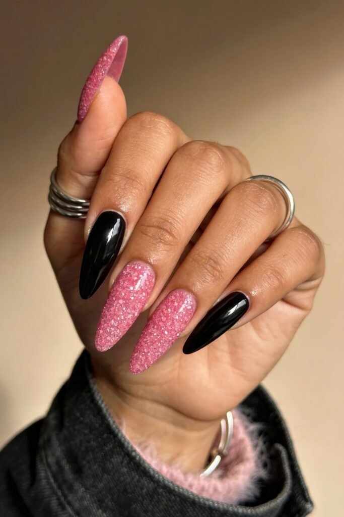 Black And Pink Nails That Look Instantly Chic 8 Almond-shaped nails with alternating black and pink glitter textures, combining smooth polish and a rough glitter finish for a stylish black and pink nails contrast.