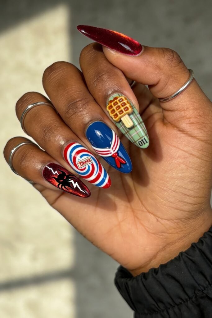Bright and colorful Stranger Things-themed nails with designs including the show's logo inside a spiral, a sailor uniform, a waffle on plaid, lightning with a spider, and “011” in black text.