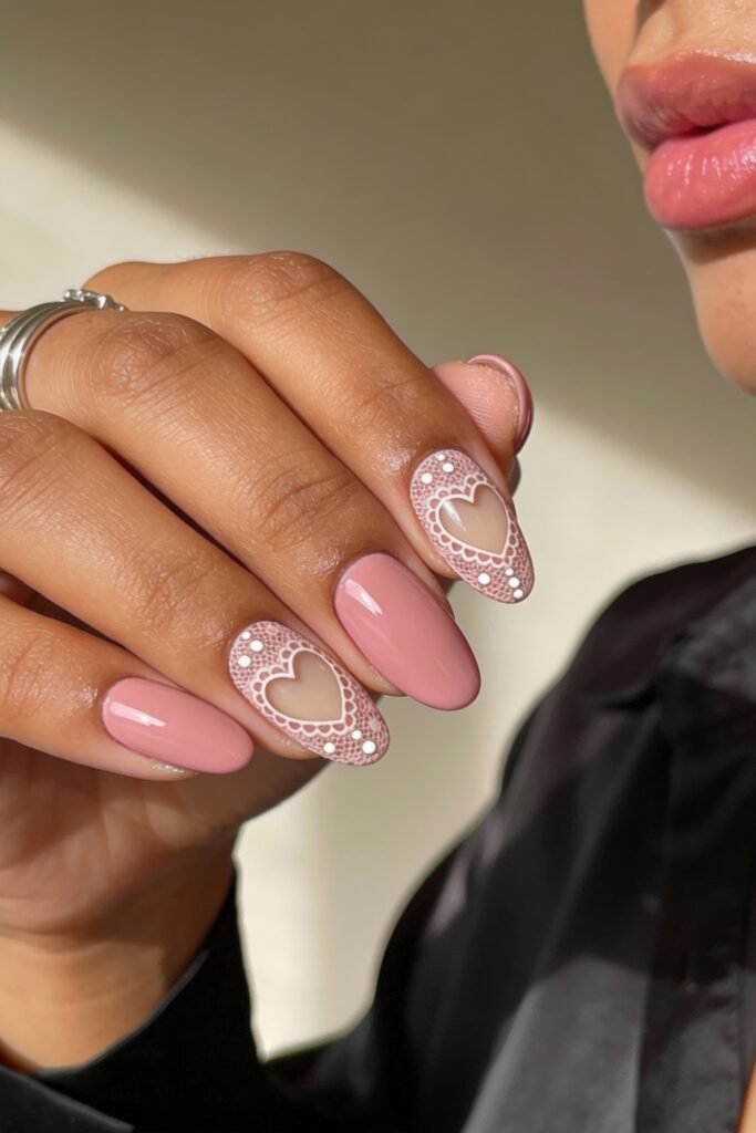Pink Valentines Nails That Feel Chic, Glossy, and New 14 Glossy pink valentines nails featuring delicate lace-style white hearts framed with dotted accents over a nude base.