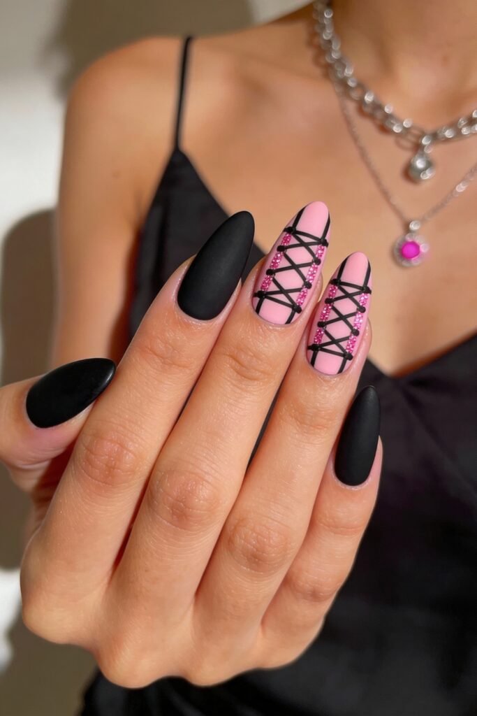 Black And Pink Nails That Look Instantly Chic 13 Matte black and pink nails with corset-style crisscross designs on the middle fingers, decorated with tiny pink gems, combining femininity and bold fashion elements.