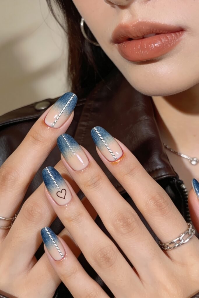 A denim-inspired gradient nail design with stitched silver accents and a small black heart, mimicking jean seams for a playful blue valentine nails interpretation.