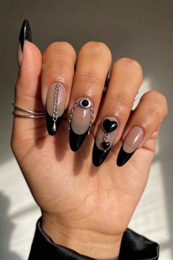 Gothic Valentines Nails That Feel Dark and Romantic 14 Almond gothic valentines nails with glossy black French tips, silver chain embellishments, and hanging black hearts for a dramatic, edgy look.