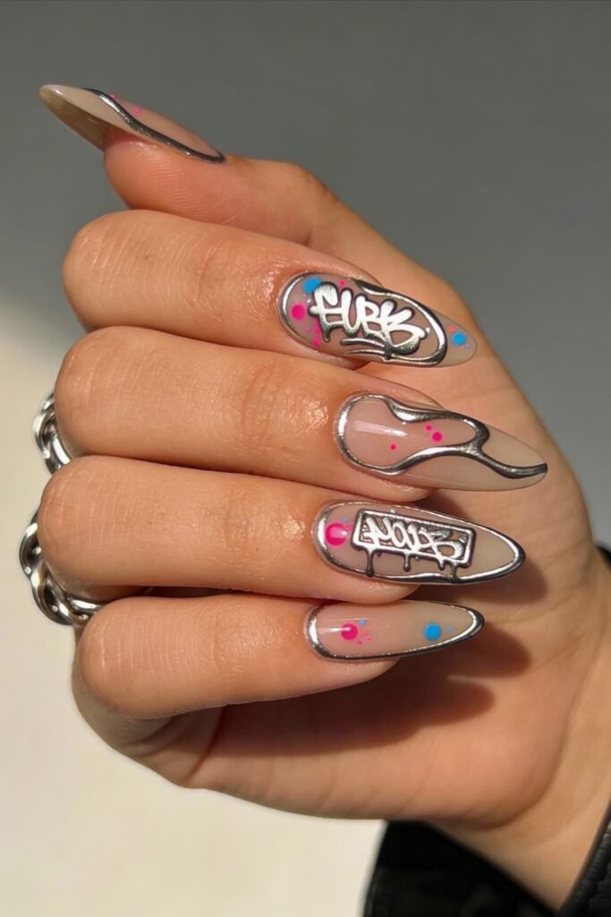 3d Nail Art Ideas That Look Luxe and Wearable 16 Edgy almond nails featuring graffiti-style 3d nail art with chrome outlines, neon splashes, and hand-lettered tags in white, creating a streetwear-inspired vibe.