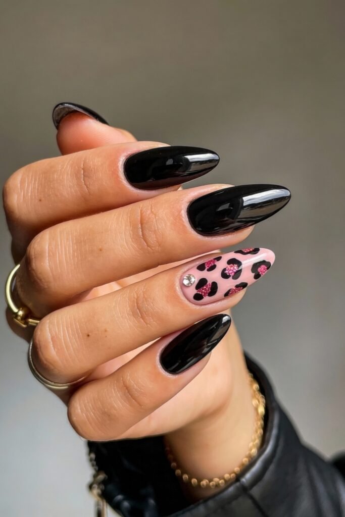 Black And Pink Nails That Look Instantly Chic 15 Glossy black almond nails with a single accent nail in pale pink covered in a pink and black leopard print, finished with a tiny rhinestone for a playful touch.