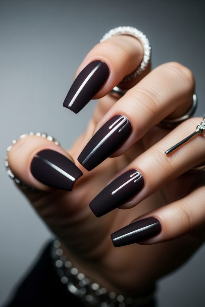 Matte plum coffin nails adorned with minimalist silver chrome stripes and dripping accents, creating a sleek and edgy winter nails look.