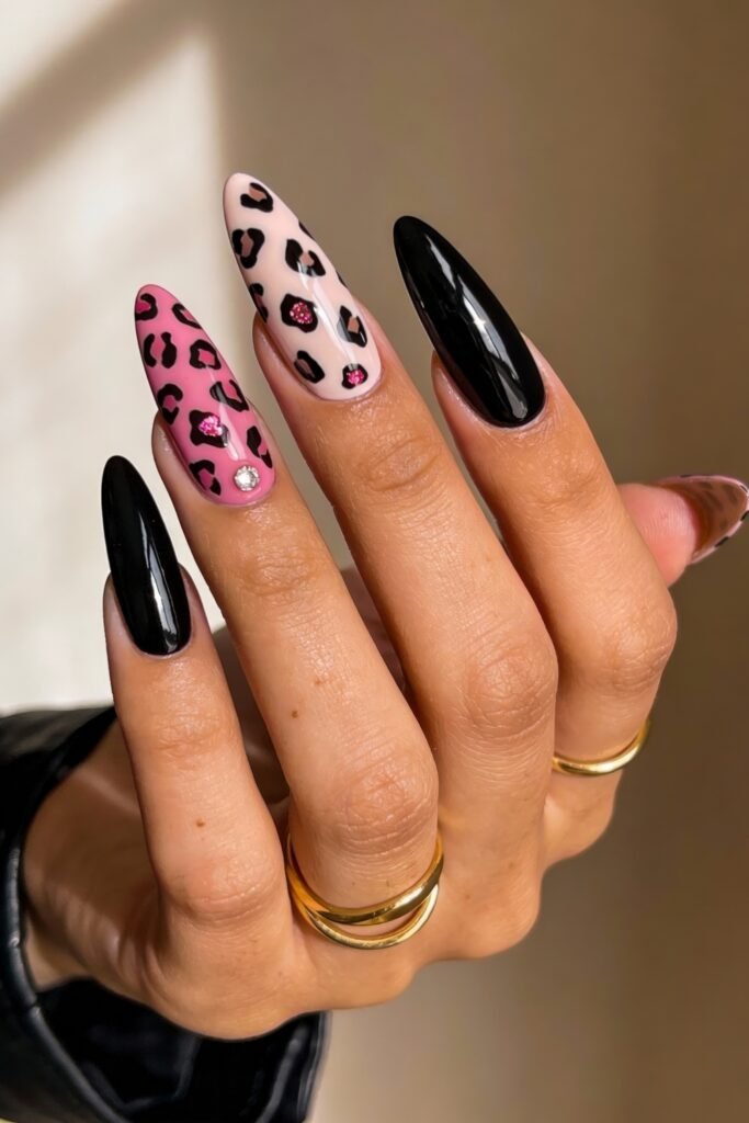 Black And Pink Nails That Look Instantly Chic 16 A vibrant black and pink nails set with glossy black polish, two accent nails featuring leopard spots in pink glitter on cream and pink bases, each accented with rhinestones.