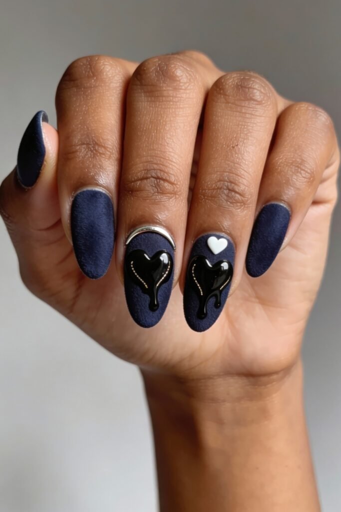 Matte navy nails with black 3D melting hearts, silver accents, and a white heart detail, offering a dramatic and stylish take on blue valentine nails.