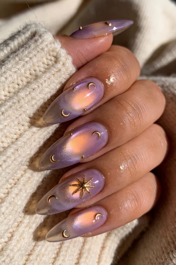 Close-up of lilac cat-eye almond nails with peachy glow, gold moon accents, and a 3D starburst charm