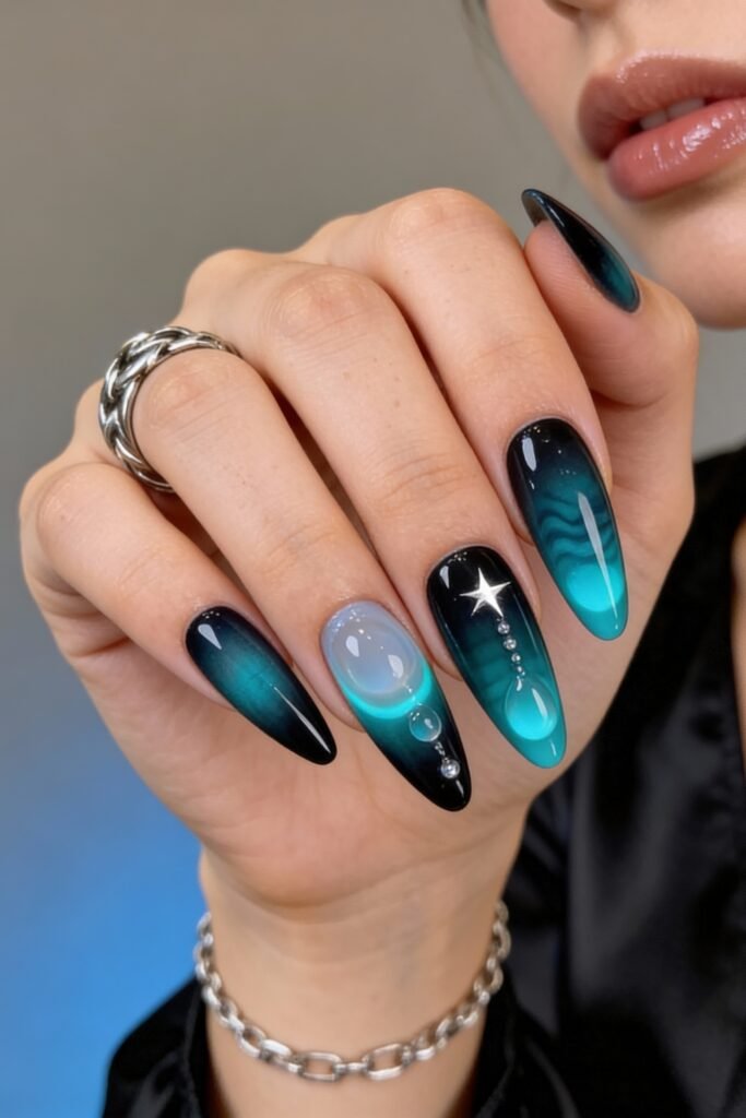Hand displaying sharp almond-shaped avatar nails in a turquoise-to-black ombre, featuring water droplet illusions, a 3D gel bubble, and a silver star, inspired by deep-sea and sci-fi motifs.