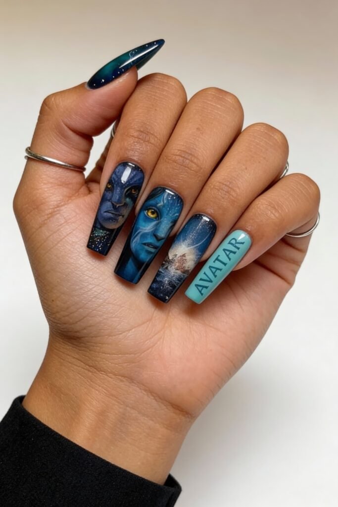 Hand with square-shaped avatar nails showcasing highly detailed portraits from the Avatar film, including glowing yellow eyes and a cinematic ocean explosion, with one nail labeled “AVATAR”.