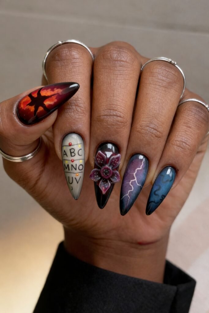 A dramatic Stranger Things nail design featuring a fiery red sky with a looming shadow figure, the alphabet wall with colored bulbs, a 3D Demogorgon flower, and lightning on a gradient background.