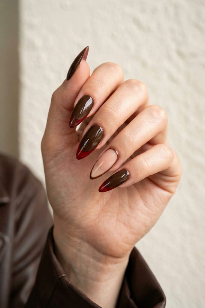 Brown And Red Nails That Make Every Look Richer 22 Hand with glossy brown almond nails featuring burgundy French tips and a nude accent nail with a slim brown outline