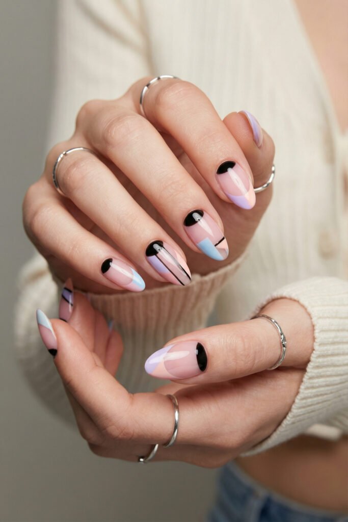 Abstract edgy spring nails in pastel pink, lilac, and blue with glossy black accents and fine lines on almond-shaped nails.
