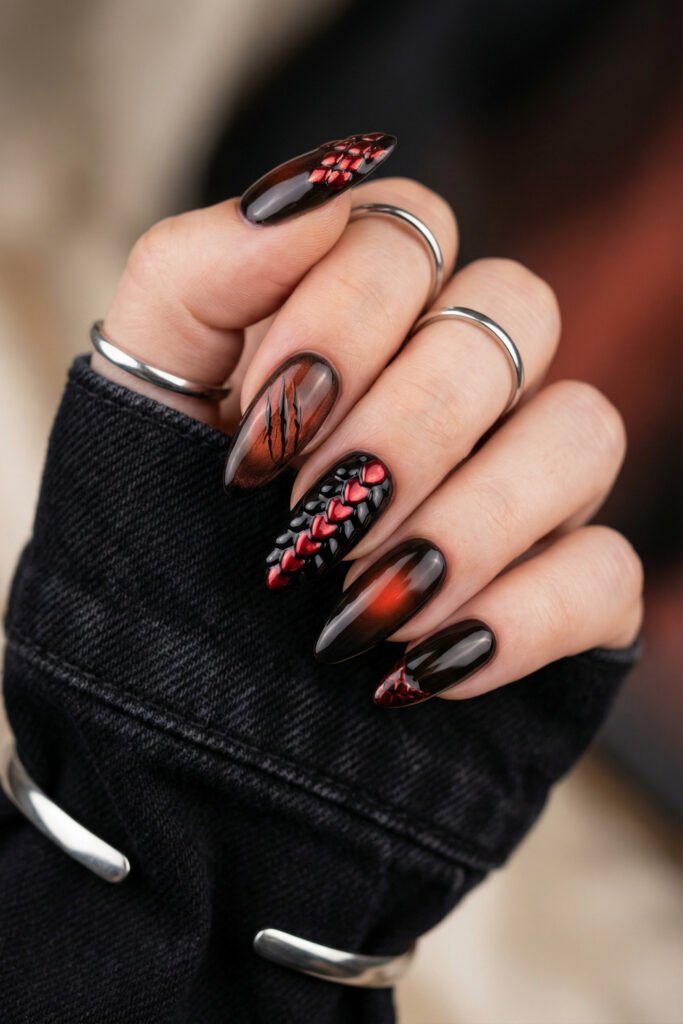 Black and Red Nails for a Bold, Polished Look 19 Hand with silver rings showing dark almond nails with red scales claw marks smoky ombre and a black tip with red web detail