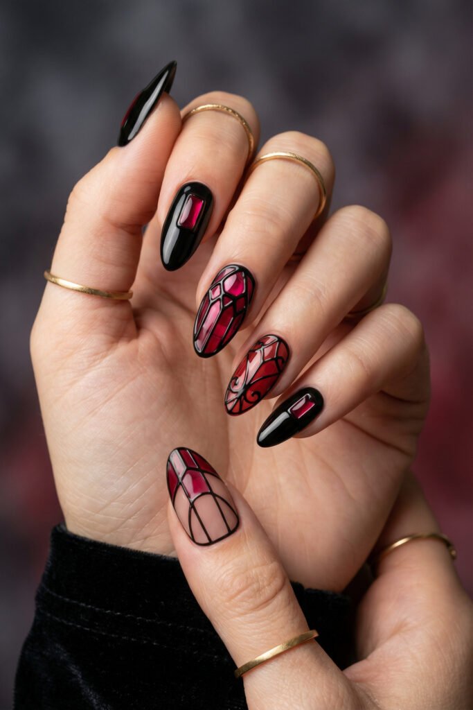 Black and Red Nails for a Bold, Polished Look 20 Hand with gold rings showing glossy black almond nails with ruby accents and stained glass red designs