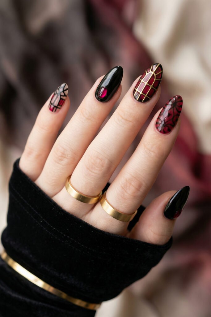 Black and Red Nails for a Bold, Polished Look 21 Hand with gold rings displaying black almond nails with a ruby accent a gold grid nail and translucent red floral art