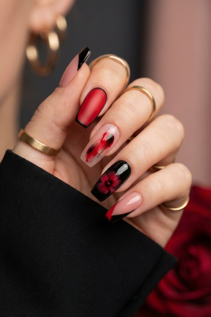 Black and Red Nails for a Bold, Polished Look 25 Hand with gold rings displaying square nails in black red and nude with matte crimson polish floral blur art and an angled French tip